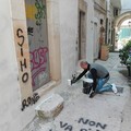 Spray nero sulle mura bianche del centro storico